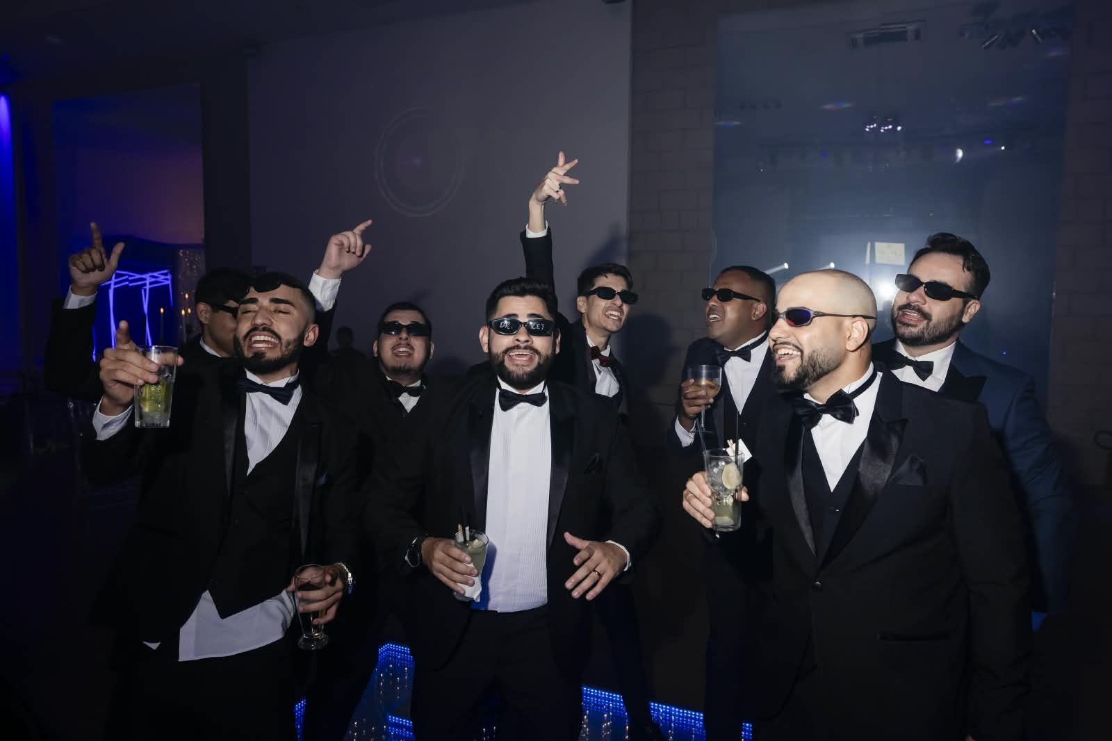 Convidados comemorando com bebidas em traje de gala