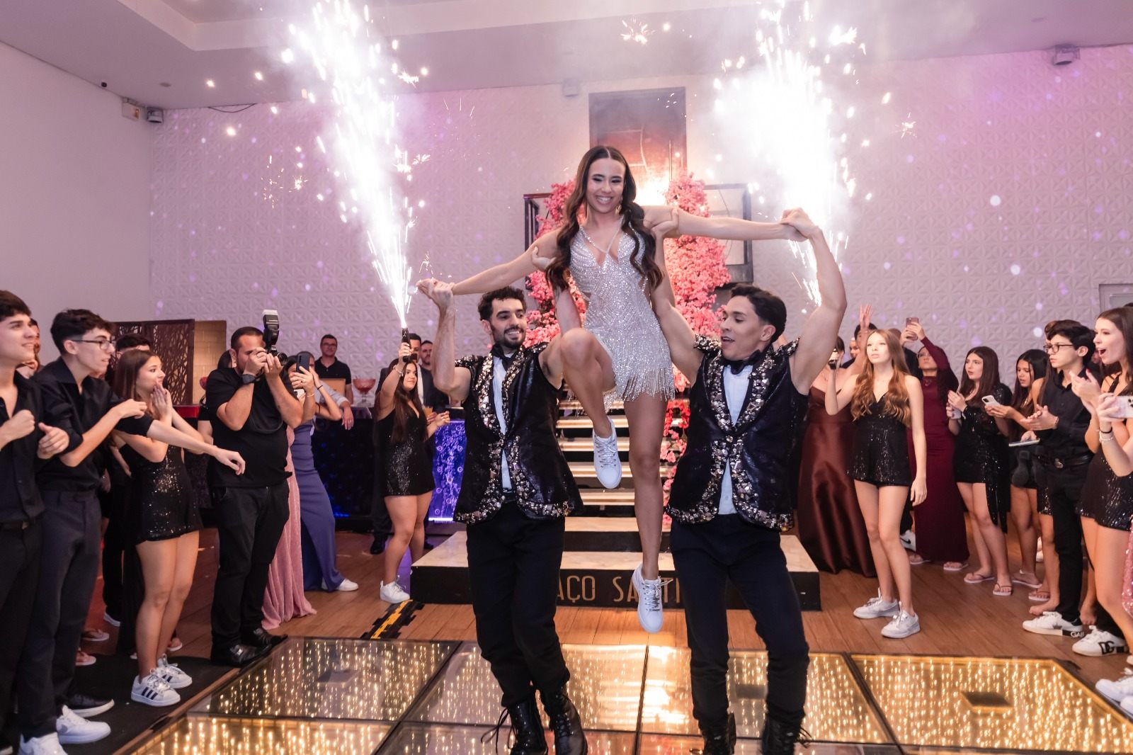 Debutante erguida por dançarinos com fogos de artifício