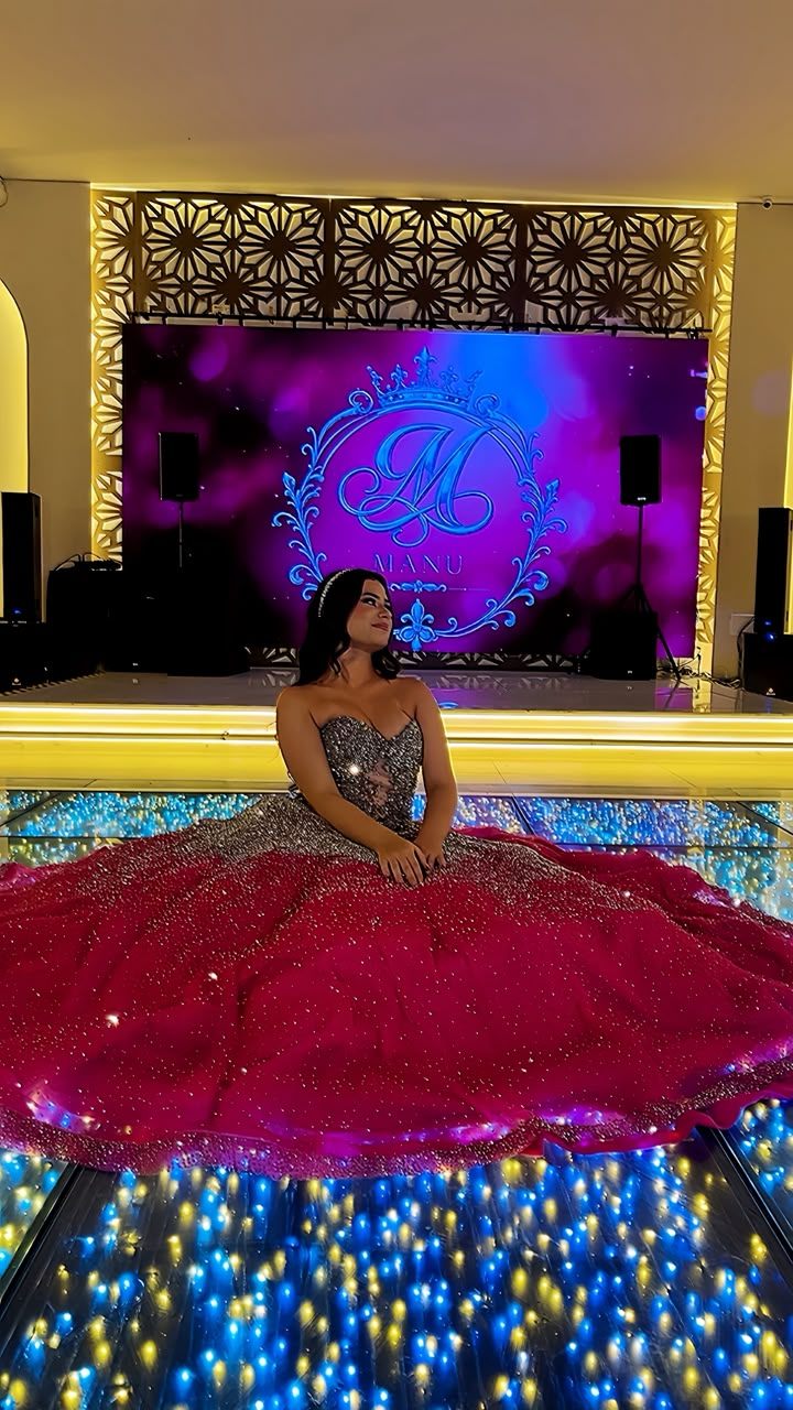 Debutante sentada em vestido vermelho e prata
